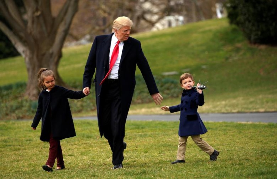 Dấu ấn 100 ngày đầu tại nhiệm của Tổng thống Donald Trump (2) - 12 Ông Trump dắt tay cháu trai Joseph Kushner và cháu gái Arabella Kushner, con của Ivanka Trump và Jared Kushner, tại bãi cỏ ở Nhà Trắng.