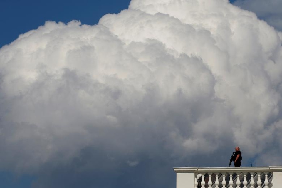 Một thành viên đội Mật vụ cầm súng đứng giám sát an ninh trên mái Nhà Trắng ở Washington.