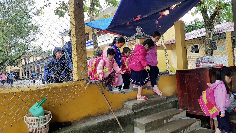 Lũ cuốn bờ sông trước trường, học sinh phải đi “xuyên tường” hàng xóm - 10 Các học sinh đi xuyên tường qua một lỗ đục ở tường của trường thông qua nhà hàng xóm