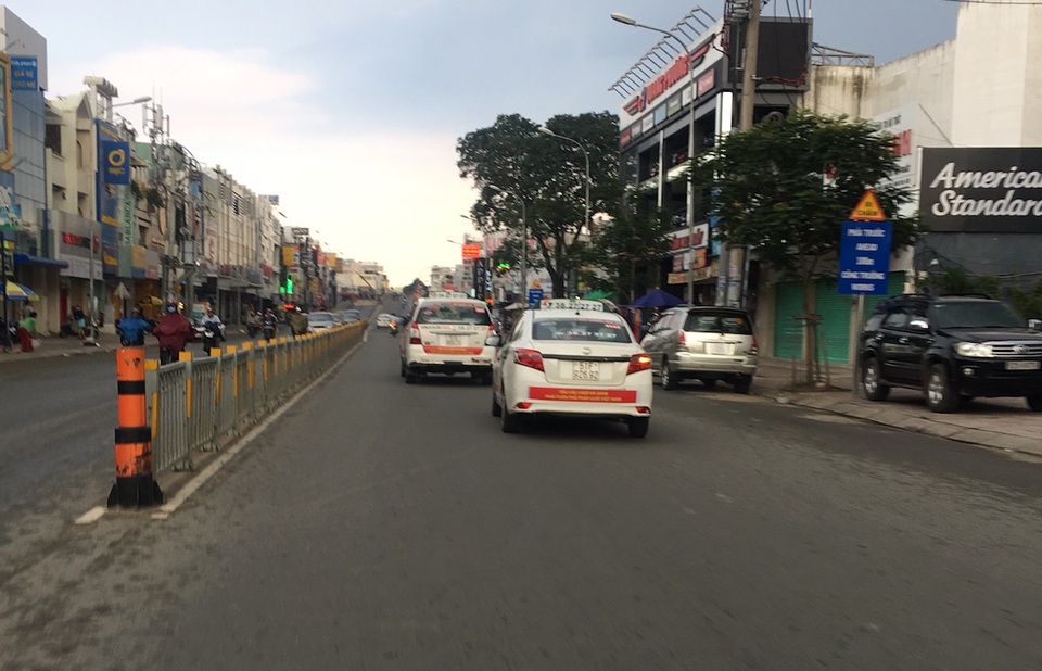 Taxi Vinasun dán khẩu hiệu phản đối Uber, Grab: Hành động rất trẻ con! - 2 Tại đường Nguyễn Oanh (quận Gò Vấp), khi thấy chúng tôi áp sát chụp hình thì 2 xe taxi của Vinasun (1 chiếc 7 chỗ, 1 chiếc 4 chỗ) bất ngờ tăng tốc