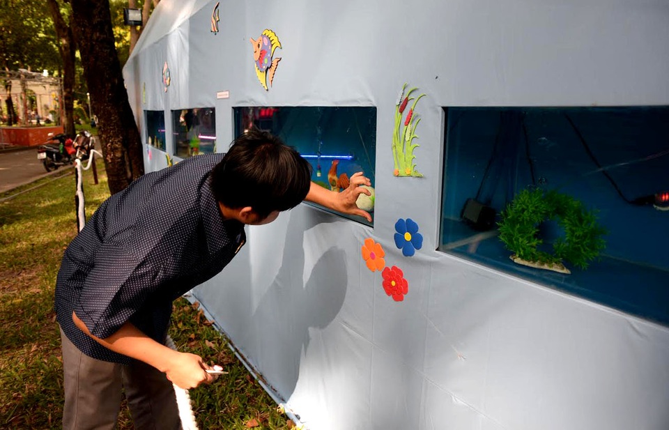 Công nhân lau dọn lại các mặt kính nơi đặt cá.