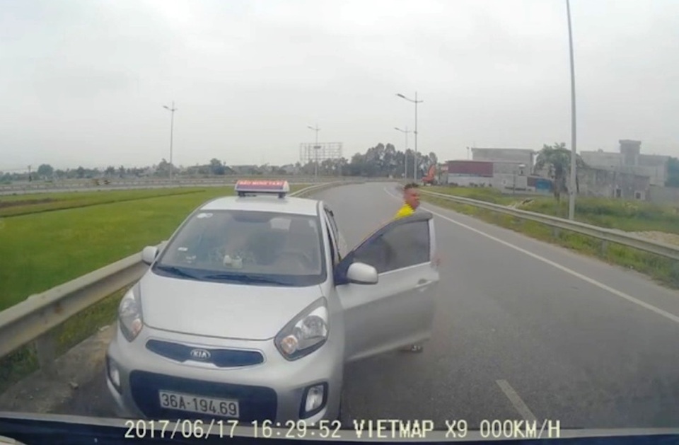Bị chặn đầu trên đường ngược chiều, tài xế taxi rút tuýp sắt đe dọa người khác - 1 Tài xế taxi mở cửa xuống xe tiến về phương tiện chặn đầu phía trước