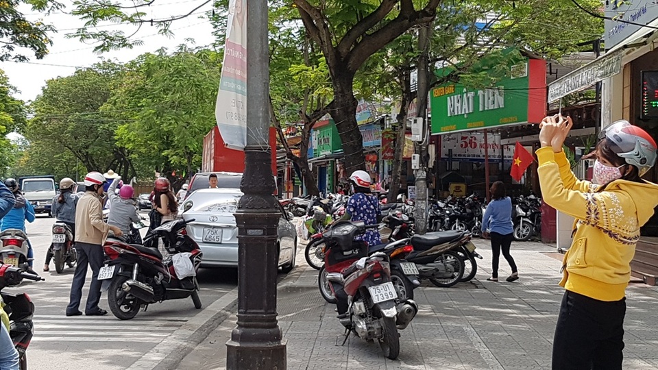 
Rất đông người dân đang đi đường cũng dừng lại thích thú chiêm ngưỡng, chụp ảnh vầng hào quang quanh mặt trời.
