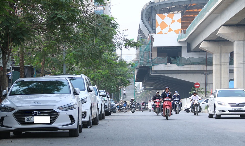 Hàng loạt ô tô xếp hàng ngay ngắn đỗ dưới lòng đường trước cửa một tiệm rửa xe trên phố Hoàng Cầu.
