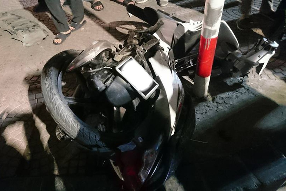 Hà Nội: Ô tô "chổng vó" trên đường, xe máy lao vào cột biển báo - 1 Xe máy hư hỏng nặng sau khi lao vào cột biển báo trên vỉa hè.