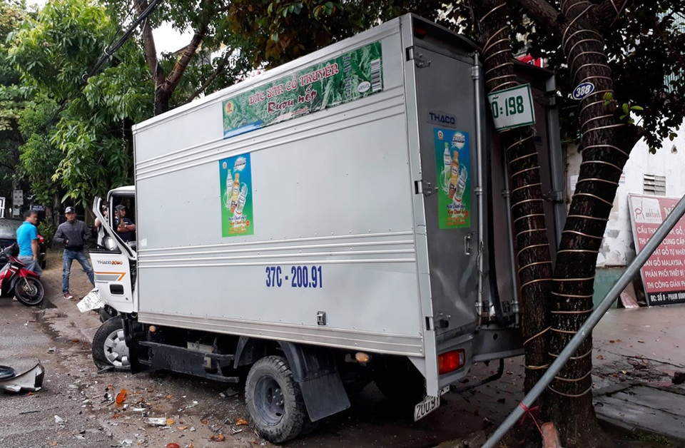 Đậu bên đường, xe tải bị xe biển xanh “ủi” nát đầu - 1 Chiếc xe tải bị ủi vào gốc cây, hư hỏng phần đầu sau cú va chạm