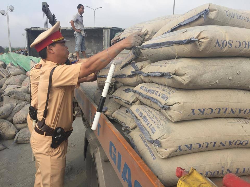 Xe ô tô của đội CSGT số 14 đến hỗ trợ chở những bao xi măng bị đổ ra đường để giải phóng hiện trường.