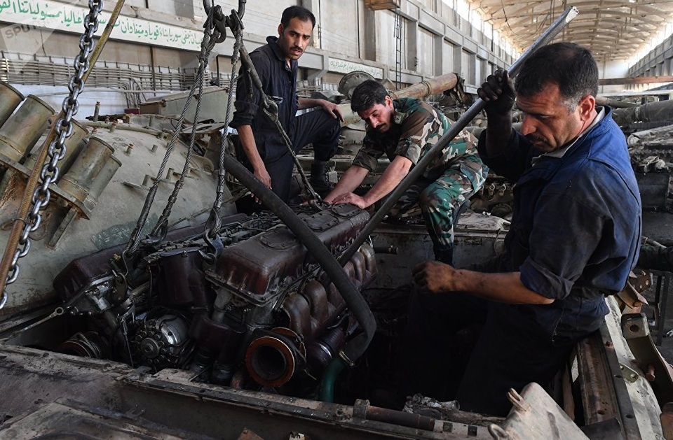Cận cảnh nơi “hồi sinh” xe tăng cho các trận chiến ở Syria - 12 Các công nhân lắp đặt một động cơ mới vào một xe bọc thép.