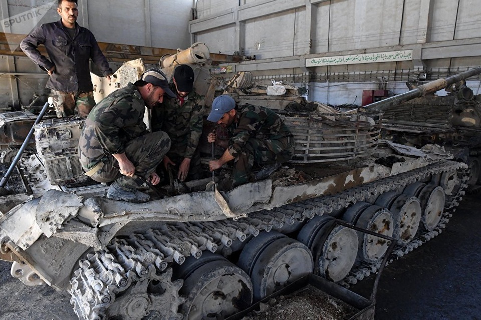 Cận cảnh nơi “hồi sinh” xe tăng cho các trận chiến ở Syria - 8 Một nhóm công nhân cùng nhau tháo lắp và sửa chữa một xe tăng bị hư hỏng nặng.