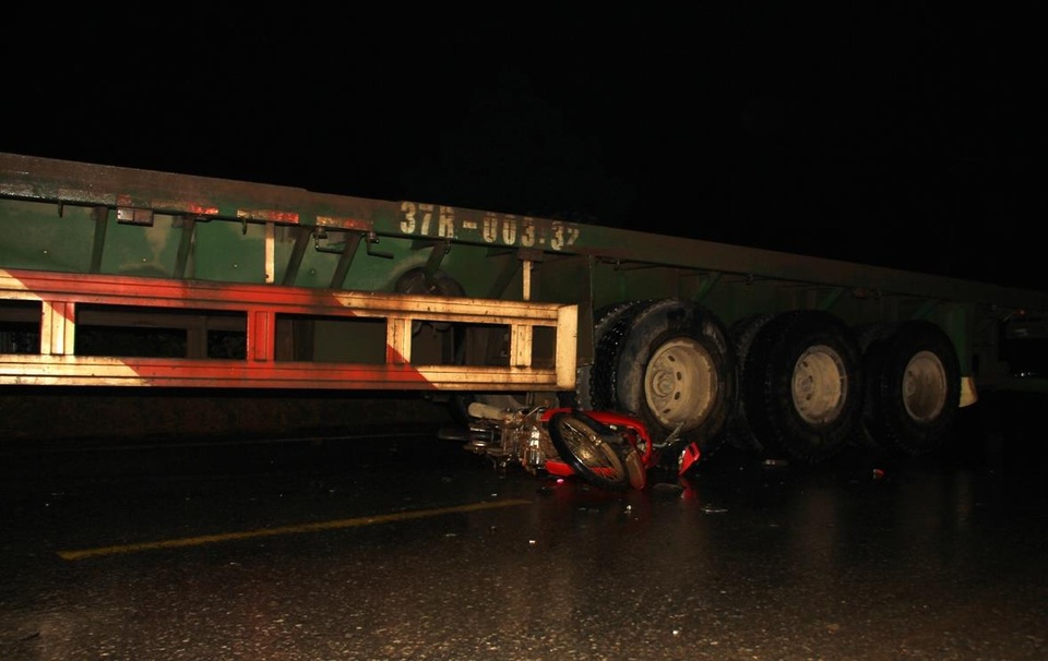 Chiếc xe máy bị cuốn vào gầm xe tải.