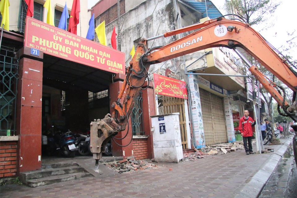Hà Nội: Điều máy xúc phá bậc thềm trụ sở phường Quốc Tử Giám - 6 Bậc thềm lấn chiếm vỉa hè của trụ sở UBND phường Quốc Tử Giám (Đống Đa, Hà Nội) đã bị lực lượng chức năng dùng máy xúc có chức năng phá bê tông để đập bỏ.