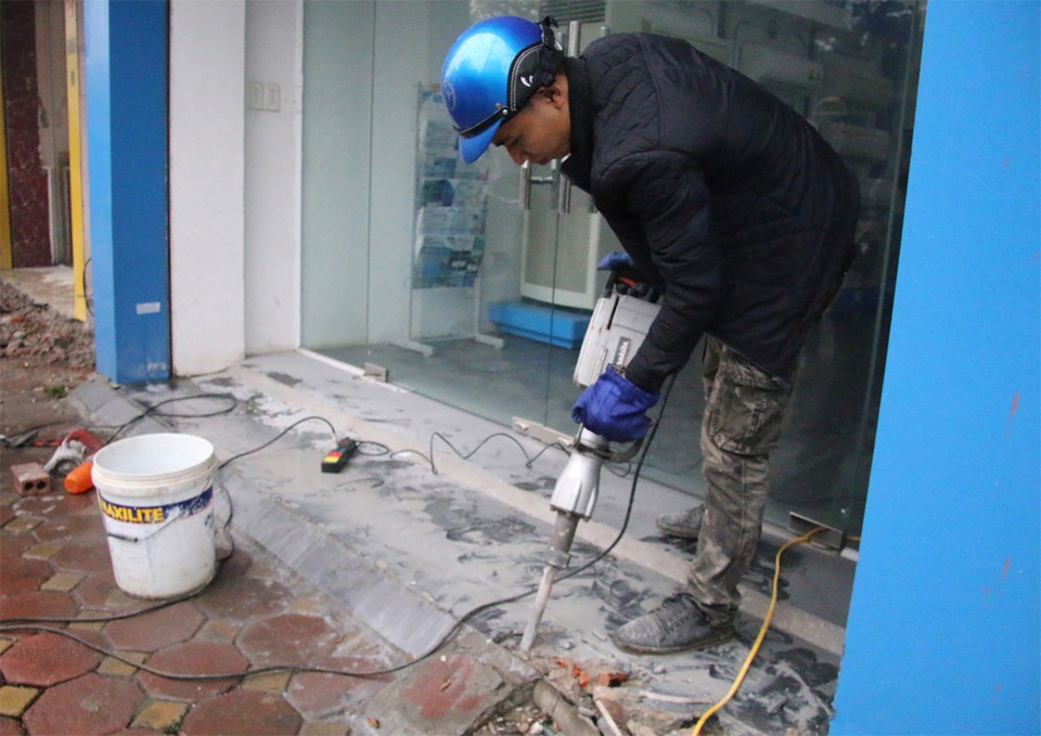 Hà Nội: Điều máy xúc phá bậc thềm trụ sở phường Quốc Tử Giám - 4 Lực lượng chức năng sáng nay tiếp tục dùng máy khoan bê tông để phá các bục bê tông lấn chiếm vỉa hè, lòng đường tại tuyến phố Tôn Đức Thắng (Đống Đa, Hà Nội).