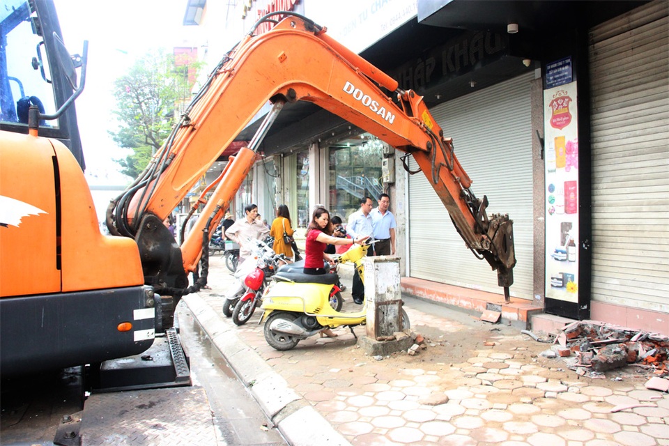 Nhà đang xây bị cưỡng chế phá dỡ phần lấn chiếm vỉa hè - 4 Lực lượng chức năng sử dụng máy múc lắp thêm mũi khoan phá bê tông để xử lý các trường hợp lấn chiếm vỉa hè, lòng đường.