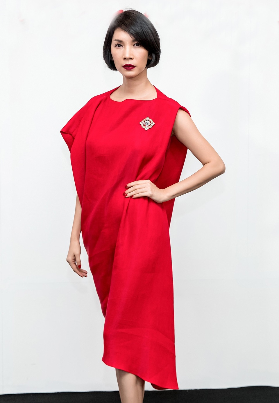 Siêu mẫu Xuân Lan diện đầm rộng, có chi tiết tạo phom bất đối xứng ở cầu vai.