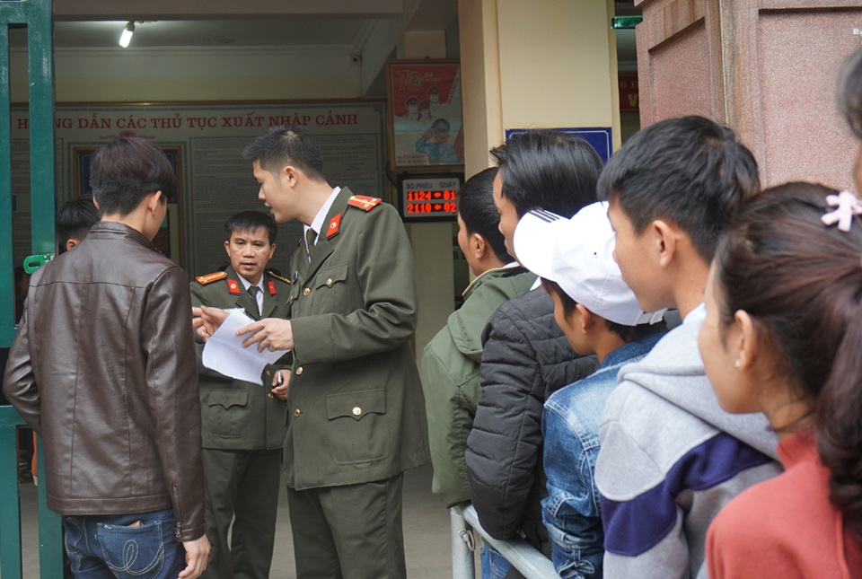 Người dân trật tự xếp hàng chờ làm hộ chiếu, “cò” hết đất làm ăn - 9 Cán bộ phòng quản lý xuất nhập cảnh hướng dẫn người dân làm thủ tục ngay từ cổng.