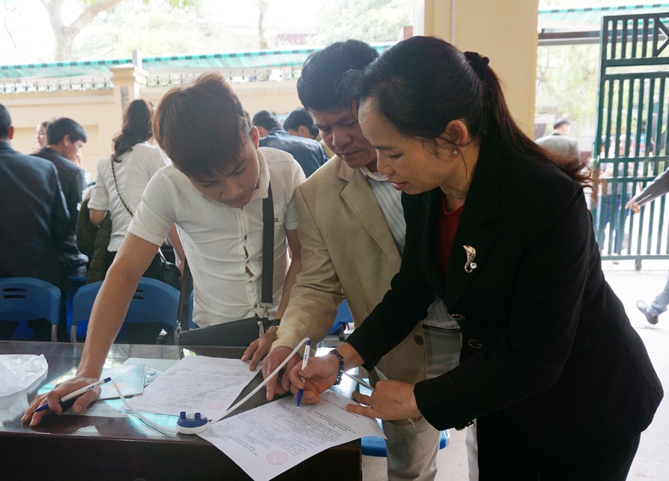 Người dân trật tự xếp hàng chờ làm hộ chiếu, “cò” hết đất làm ăn - 7 Người dân ghi tờ khai đề nghị cấp hộ chiếu.