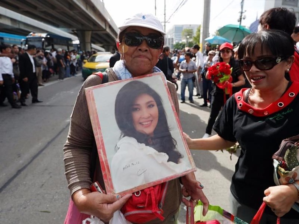 
Người ủng hộ mang theo ảnh của bà Yingluck để ủng hộ bà trước phiên tòa (Ảnh: Reuters)
