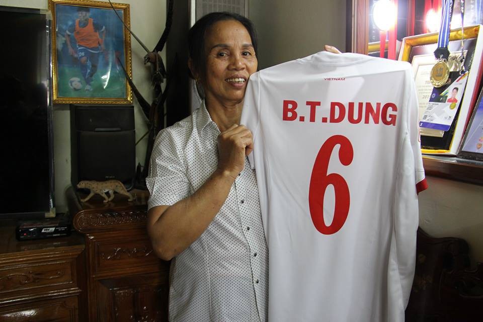 Bố "người nhện" Bùi Tiến Dũng tiết lộ lý do không sang Trung Quốc - 3 Bà Dương Thị Hường, mẹ trung vệ Tiến Dũng bên chiếc áo của con trai