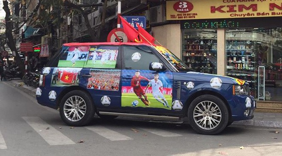 Hàng loạt xe "thay áo" Quốc kỳ tiếp lửa U23 Việt Nam trước chung kết - 14 Một chiếc Range Rover màu xanh trang trí ấn tượng với hình ảnh của các cầu thủ U23 và cổ động viên Việt.