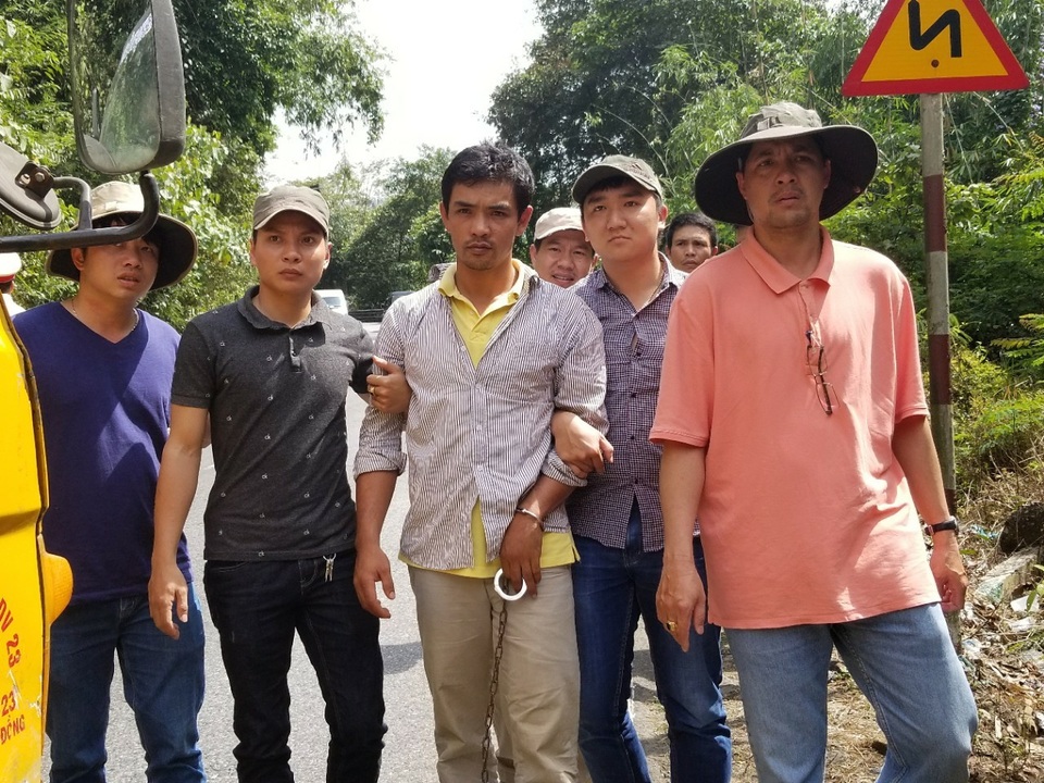Giết chủ nợ rồi phi tang xác trong rẫy cà phê - 2 Cơ quan chức năng dẫn giải Vũ (áo trắng) đến hiện trường