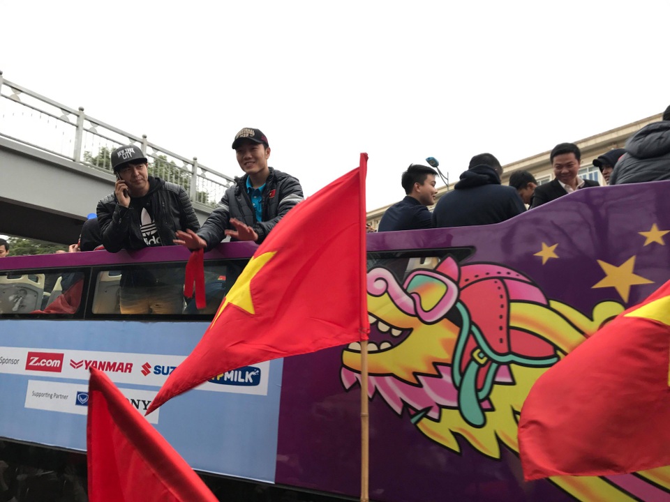 Xe chở U23 Việt Nam diễu hành giữa rừng cờ đỏ sao vàng - 6
Đội trưởng Xuân Trường giơ tay chào người hâm mộ