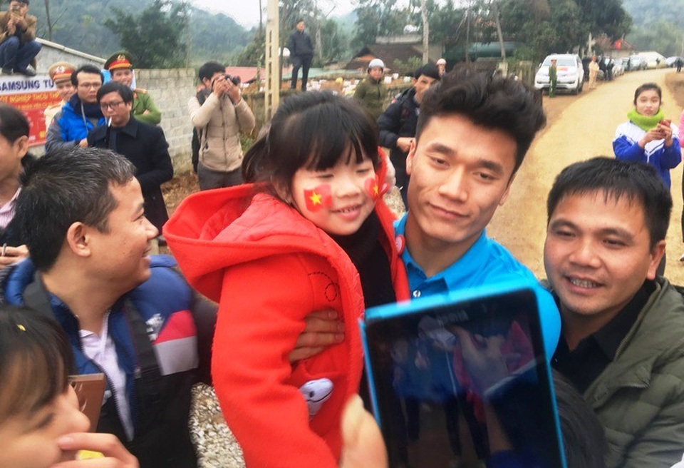 Thủ môn Bùi Tiến Dũng: Ngày trước đi đá giải về vẫn lên nương, lên rẫy - 10
Khi vừa thấy cháu nhỏ, Tiến Dũng cúi xuống bế cháu bé lên để chụp ảnh