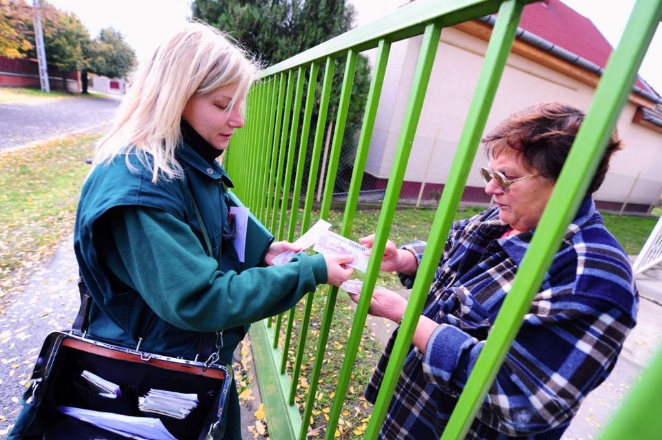 Nhân viên bưu chính Bernadett Kasza thuộc ngành bưu điện Hungary đang chuyển tiền tận tay tới một khách hàng ở thủ đô Budapest. Nữ nhân viên này từng nhận giải thưởng Viên chức Bưu chính xuất sắc nhất năm 2012.