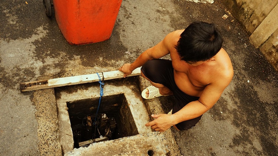 Ông Hòa đang kiểm tra lại hố ga chính vì nước vẫn còn xâm xấp, mặc dù không có triều cường hay mưa lớn