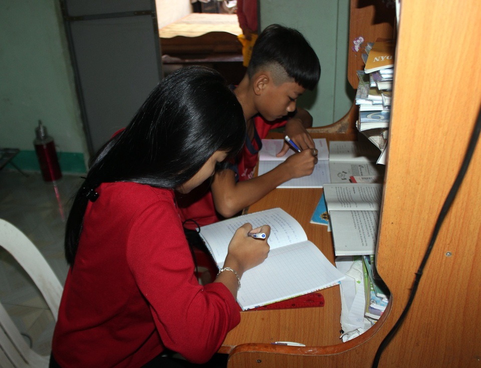 Vì căn phòng nhỏ, nên 2 anh em phải học chung 1 cái bàn 