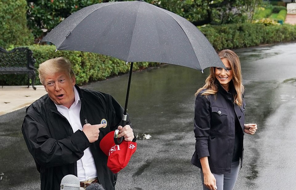Ông Trump bị chỉ trích vì che ô một mình, để vợ đầu trần dưới mưa - 1 Ông Trump che ô một mình, để vợ đầu trần ngoài mưa (Ảnh: AFP)