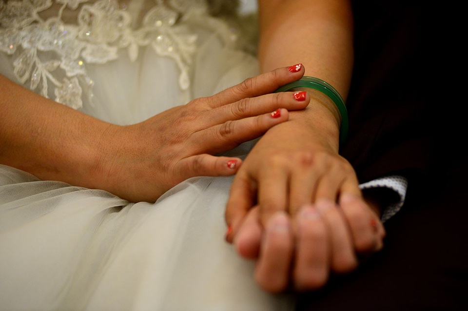 Những cái nắm tay chặt của 1 cặp vợ chồng trong lúc chờ làm lễ.