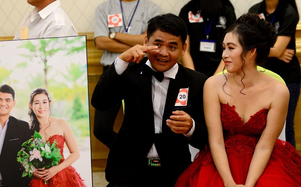 Chị Nguyễn Thị Mới, 36 tuổi bị cụt chân do lao động từ bé. Chị ân cần nhìn người chồng đang dùng ký hiệu giao tiếp với cặp đôi đối diện.