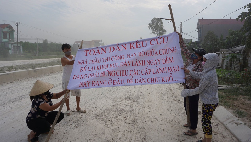 Dân nhiều xã mang đá, gậy gộc ra đường chặn xe tải - 1 Người dân mang băng rôn ra đường kêu cứu vì bụi.