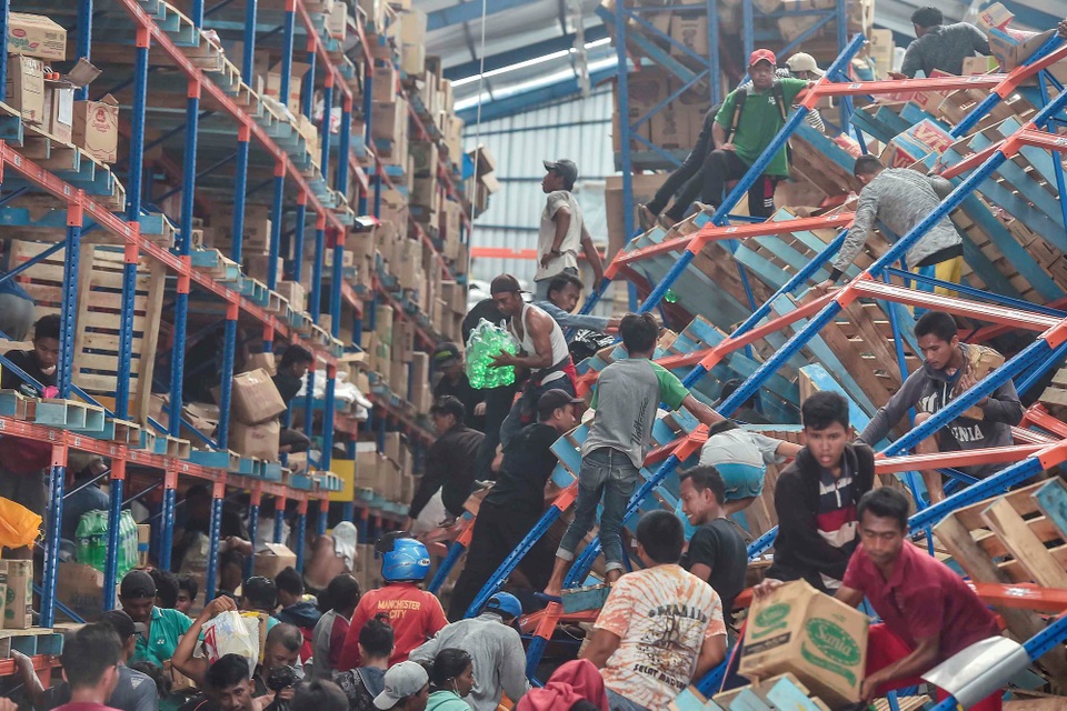 3 ngày sau thảm họa kép tại Indonesia: Khó khăn chồng chất - 4 Người dân hôi của tại một nhà kho ở Palu sau thảm họa. (Ảnh: Reuters)