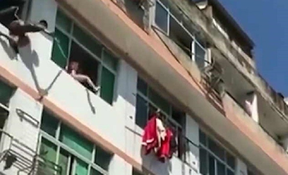 Kịch tính cảnh nhân viên cứu hỏa dùng vòi rồng ngăn người nhảy lầu tự tử - 2 Nhân viên cứu hỏa treo mình như người nhện để ngăn cản cô gái tự tử