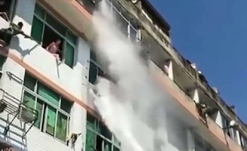 Kịch tính cảnh nhân viên cứu hỏa dùng vòi rồng ngăn người nhảy lầu tự tử - 3 Vòi rồng phun thẳng vào người cô gái