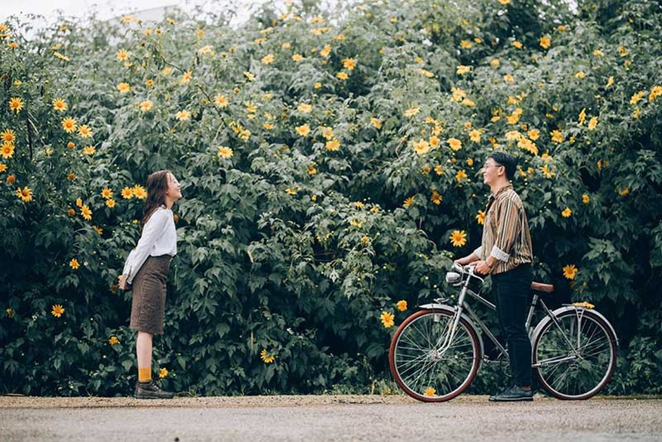 Ảnh cưới ngọt ngào mùa hoa dã quỳ của cặp đôi có tính cách “ngược chiều” - 1 Phi Hoàng (sinh năm 1995) và Thùy Mi (sinh năm 1994) đều làm nhân viên lễ tân ở một khách sạn tại quê nhà Nha Trang. Cũng chính tại đây cả hai có cơ hội gặp gỡ, quen biết rồi trở nên thân thiết từ lúc nào chẳng ai hay biết. Nhưng trước đó thì Hoàng và Mi đều đã có người yêu, họ đơn thuần xem nhau như những người đồng nghiệp không hơn không kém.
