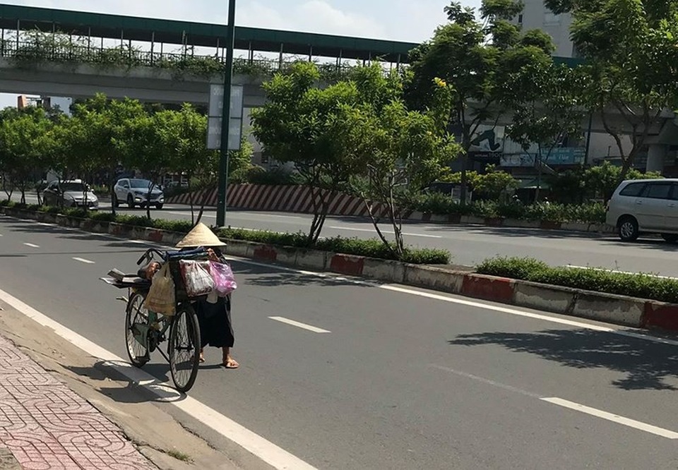Bà già ve chai liêu xiêu giữa dòng đời bất tận - 4 Giữa đường trưa nắng gắt, cái dáng còng còng nhỏ bé của cụ liêu xiêu bên chiếc xe đạp cũ. Ảnh: VIỆT HOA