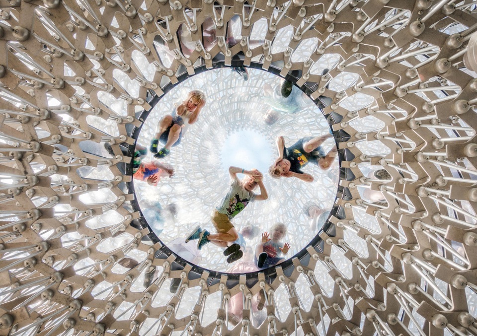 Trẻ nhỏ nằm trên sàn kính để quan sát những du khách ở bên dưới. Ảnh chụp tại một công trình nằm bên trong Vườn thực vật hoàng gia Kew, London, Anh. Ảnh: Omer Kanipak