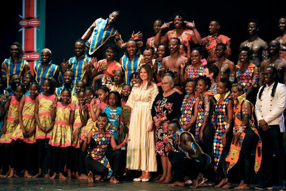 Bà Melania chọn váy màu vàng khi chụp ảnh cùng Đệ nhất phu nhân Kenya Margaret Kenyatta và các diễn viên tại nhà hát quốc gia Kenya.