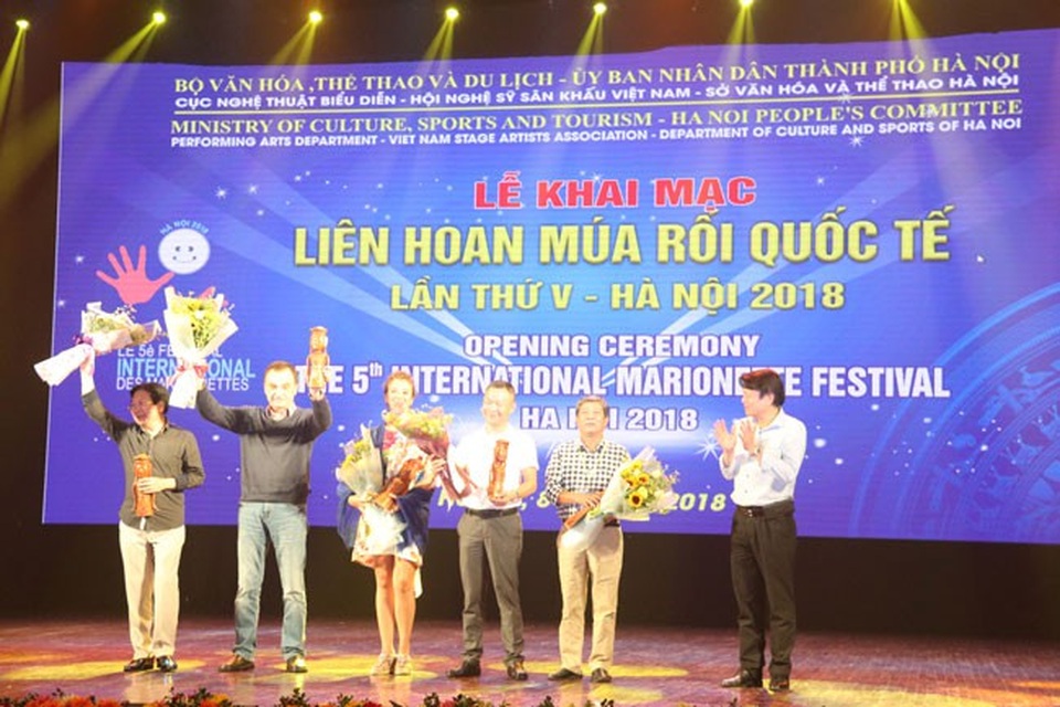 Khai mạc Liên hoan múa rối quốc tế 2018 tại Hà Nội - 3 Quyền Cục trưởng Cục Nghệ thuật biểu diễn Nguyễn Quang Vinh trao hoa và lưu niệm cho Hội đồng nghệ thuật.