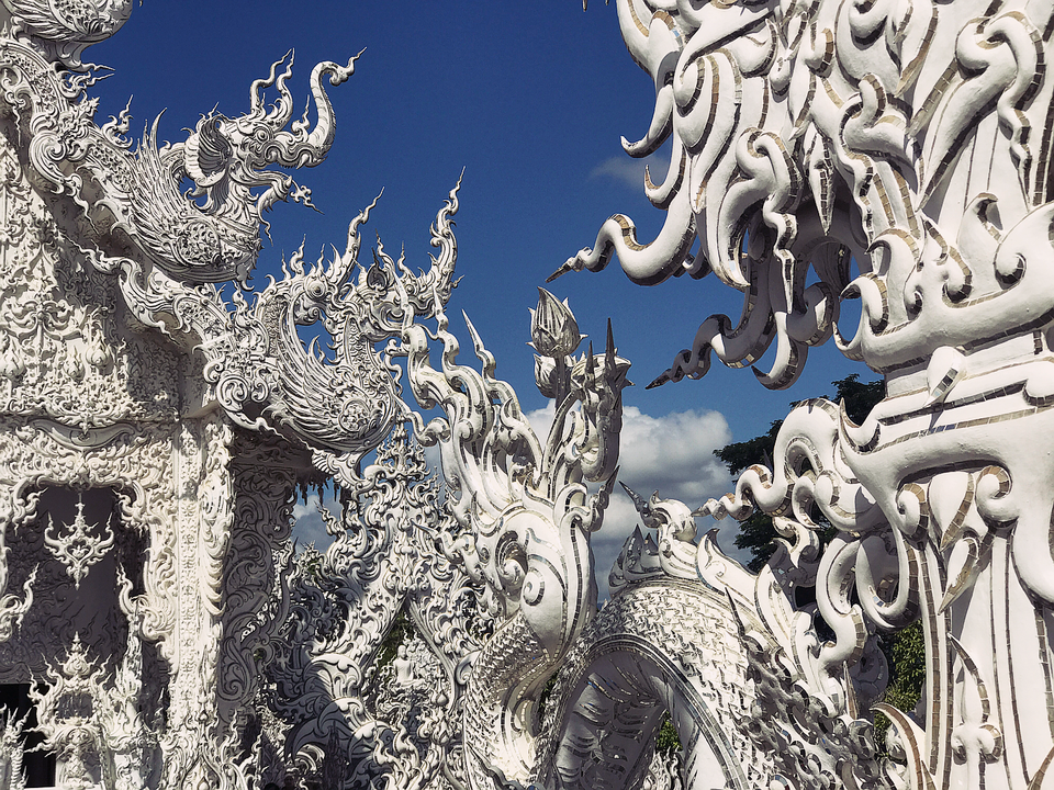 Ba ngôi chùa nổi tiếng ở Chiang Mai - Chiang Rai - 8
Wat Rong Khun được thiết kế bởi Chalermchai Kositpipat, một nghệ sĩ thị giác nổi tiếng của Thái Lan. Đến nay ngôi chùa vẫn chưa hoàn tất. Khi hoàn thiện quần thể này sẽ có chín tòa nhà bao gồm một hội trường để cất giữ các di tích Phật giáo, một phòng thiền, phòng trưng bày nghệ thuật....