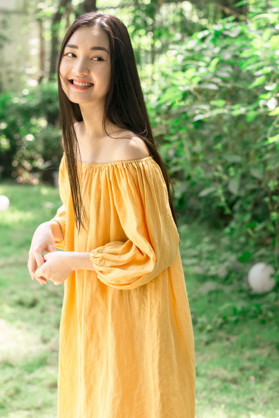 Nàng thơ xứ Huế lựa chọn cho mình một chiếc đầm suôn trễ vai màu vàng, trang điểm nhẹ nhàng và đi chân trần dưới nắng sớm. Vốn hữu vẻ đẹp tự nhiên với sống mũi cao, lông mày thanh tú, đôi mắt trong và mái tóc đen thẳng mang đậm nét Á Đông, nụ cười tỏa nắng ở bộ ảnh này khiến Nàng thơ càng thêm dịu dàng, đằm thắm.