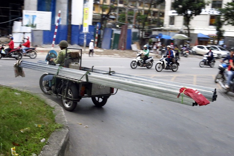 Xe chở sắt thép "siêu cồng kềnh" hoành hành ở Hà Nội - 12 Chiếc xe 3 bánh chở hàng chục thanh thép dài 5-6m xoay ngang tương đương với barie di động trên đường.