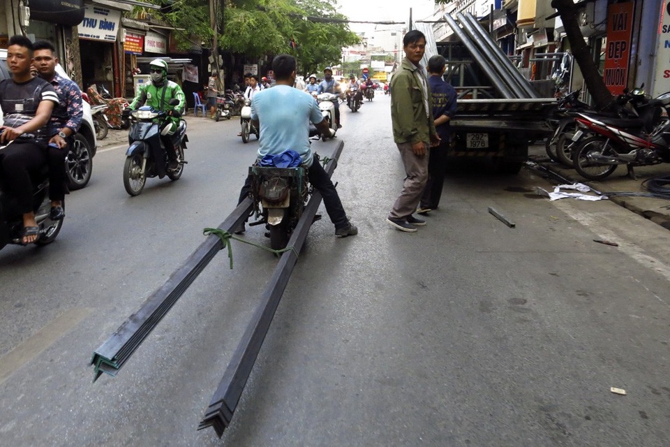 Xe chở sắt thép "siêu cồng kềnh" hoành hành ở Hà Nội - 4
Một người đang vận chuyển những thanh thép chữ V trên phố La Thàn - con phố chuyên bán các loại sắt thép đủ loại. Phương tiện vận chuyển chủ yếu là xe gắn máy, chỉ những chuyến hàng nhiều mới được vận chuyển bằng ô tô.