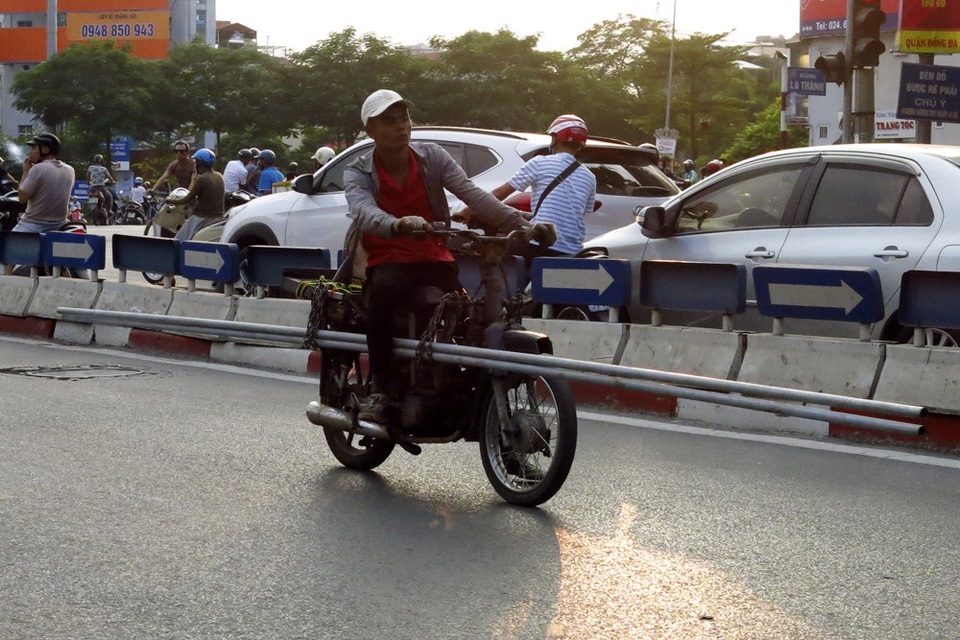 Xe chở sắt thép "siêu cồng kềnh" hoành hành ở Hà Nội - 7 Những chuyến xe chở thép ống vun vút trên đường phố. Chiếc xe máy được gia cố giá đỡ hai bên và nhiều dây xích chằng buộc là loại xe chuyên dụng để chở mặt hàng này.