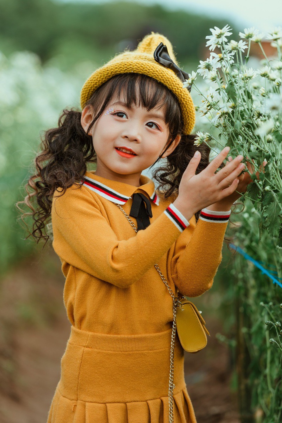 Tan chảy trong bộ ảnh bên cúc họa mi của mẫu nhí Hà Thành - 9 Ali tạo dáng rất linh hoạt trong bộ ảnh, đôi mắt to tròn của cô bé thu hút mọi ánh nhìn.