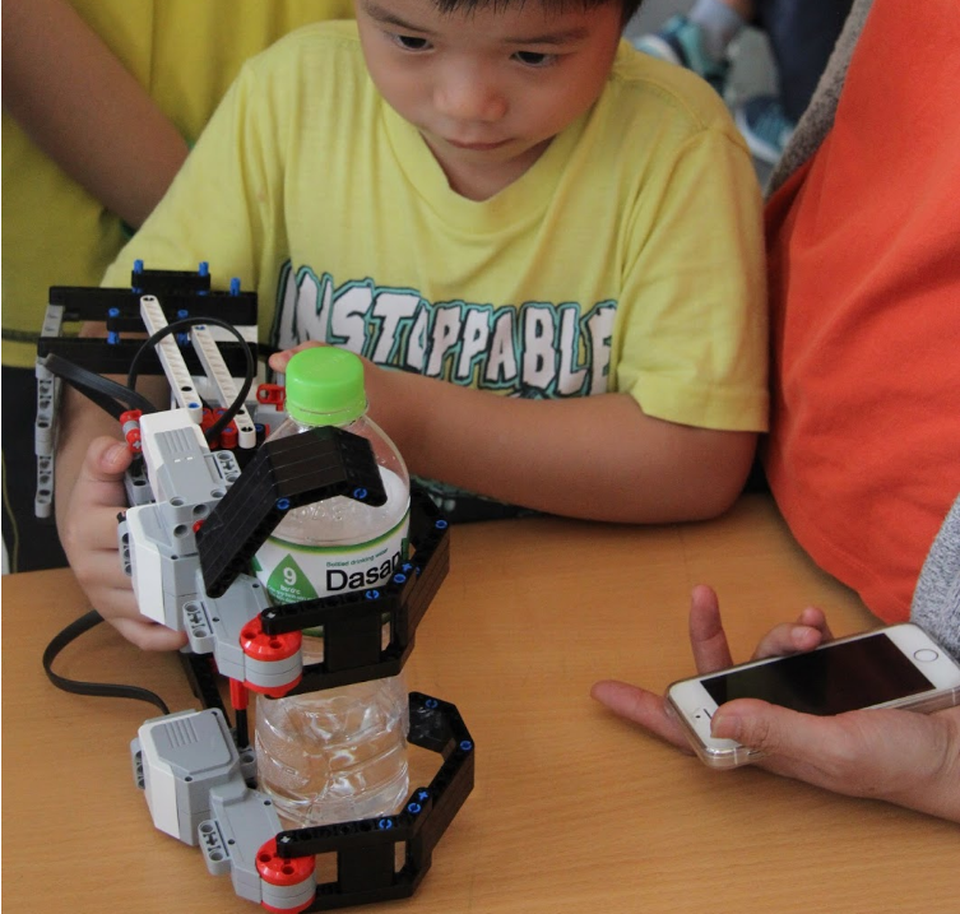 Học sinh Hà Nội thích thú trải nghiệm công nghệ 4.0 tại GART Expo 2018 - 4 Cánh tay robot đang “trổ tài” gắp chai nước.