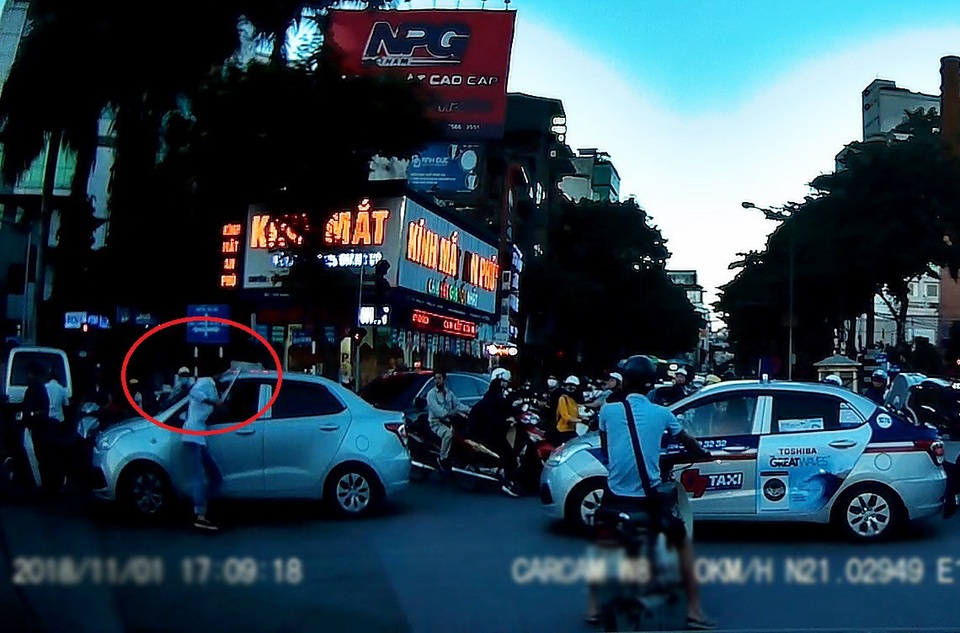 Hà Nội: Tài xế taxi dùng tuýp sắt để giải quyết mâu thuẫn sau va chạm giao thông - 1 Sau khi bị đánh, lái xe taxi đã dùng một tuýp sắt lấy ở trong cốp xe xuống rồi lao đến định ăn thua với lái xe ô tô phía trước (Ảnh: Cắt từ clip)