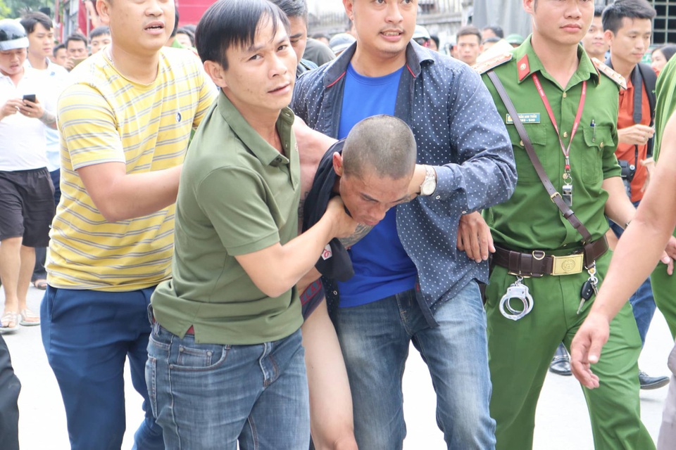 Nghi ngáo đá, ném con từ mái nhà xuống đất - 3 Công an khống chế Lê Ngọc Hà và dẫn giải về trụ sở để lấy lời khai.